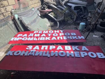рекламный ролик: Рекламная вывеска красного цвета с объемными белыми буквами. На