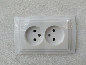 standart qapi olculeri: Ağ rəngdə, iki yuvalı elektrik rozetkası. Divara quraşdırılıb və