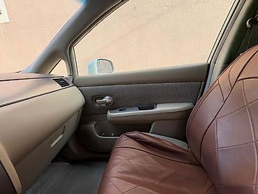 nisan note: Ağ rəngli Nissan Tiida sedan. Avtomobilin salonu açıq bej tonlarda — 5