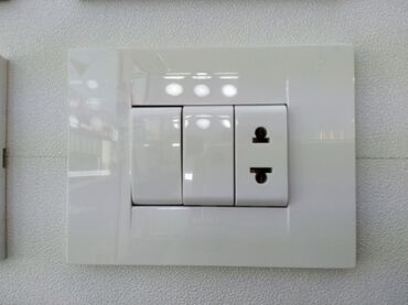 ev qaplsl: Ağ rəngdə, düzbucaqlı formalı elektrik açarı və rozetka paneli. İki