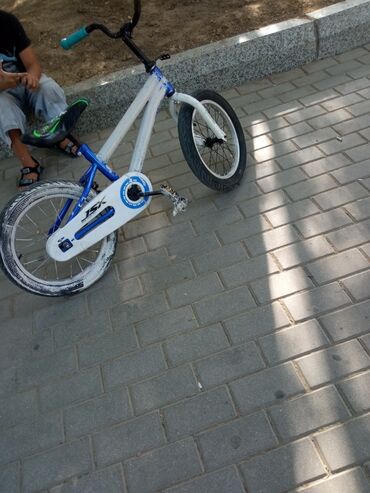 Ağ və göy rənglərdə olan uşaq BMX velosipedi. Velosipeddə "BMX Racing"