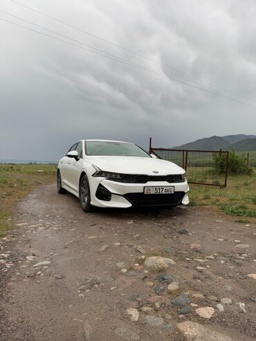 дом на калесах: Белый седан Kia K5 — это современный автомобиль с элегантным дизайном
