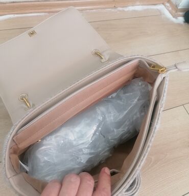 Torbe: Ženska torba sa preklopom od veštačkog krzna u bež boji. Torba ima dve — 12