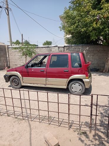 передвижные дома: Автомобиль Daewoo Tico красного цвета с бежевой нижней частью. Имеет