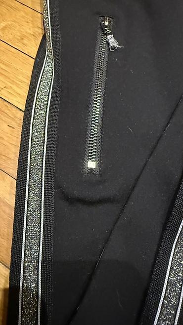 Pantalone, Farmerke, Šortsevi: Ženske crne pantalone uskog, elegantno-sportskog kroja. Model je dugih — 2