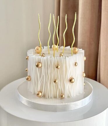 Tortlar: Zərif dizaynlı, ağ rəngli tort. Tortun ətrafı dalğalı bəzəklərlə əhatə — 6