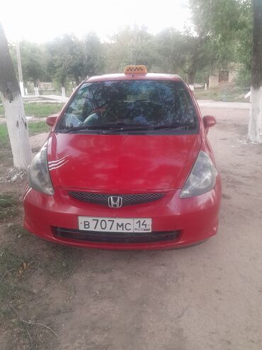 шинный центр бишкек кудайберген: Красный хэтчбек Honda Fit. На передней части автомобиля виден логотип