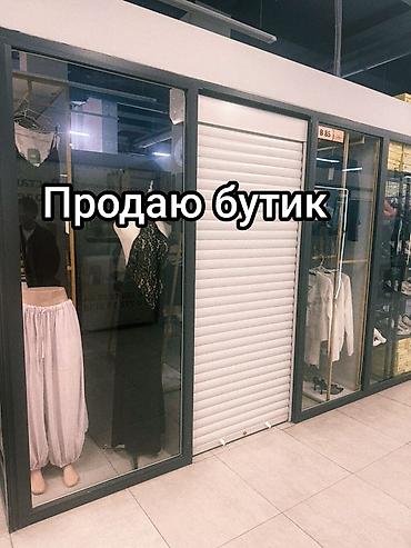 Бутик одежды в торговом центре. - Торговая секция с витринными окнами