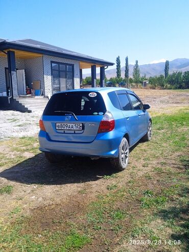 ролик для авто: Хэтчбек Honda Fit в ярком синем цвете, оснащенный стандартными литыми