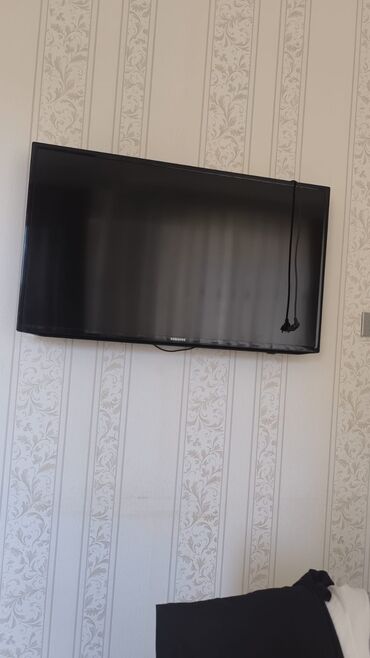 Divara quraşdırılmış Samsung düz ekran televizor. Qara rəngdədir və
