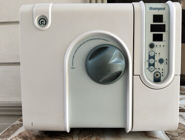 Çəngəllər: Runyes markalı ağ rəngli avtoklav sterilizasiya aparatı. Bu avtoklav