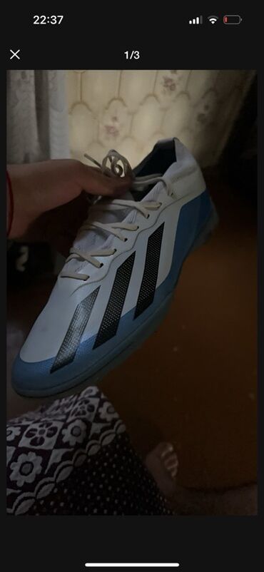 Botinkalar: Ağ və açıq mavi rəngdə olan Adidas futbol ayaqqabısı. Ayaqqabının
