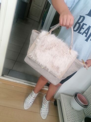 Torbe: Ženska torba sa preklopom od veštačkog krzna u bež boji. Torba ima dve — 2