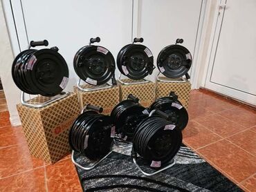staklo za tus kabinu: Set od nekoliko crnih produžnih kablova (motalica) na koturu. Svaki