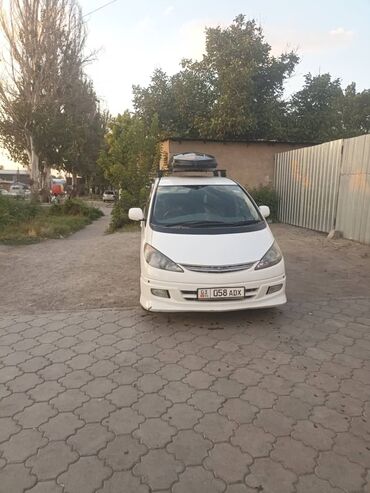 семиместные машины: Белый минивэн Toyota Estima, оснащенный багажником на крыше