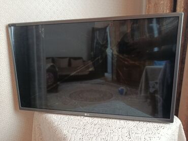 mikrofon dayaq: LG televizor (ekran ölçüsü təxminən 40–43 düym). Nazik çərçivə, gümüş