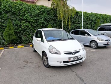 машине арзан: Белый хэтчбек Honda фит с пятидверным кузовом, припаркованный на