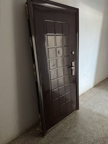 Напольные покрытия: Tünd qəhvəyi rəngdə, kvadrat formalı detallarla bəzədilmiş metal qapı