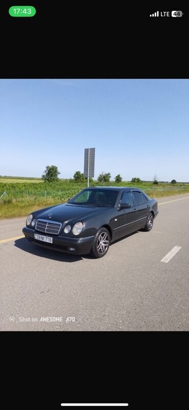 Tünd rəngli Mercedes-Benz E-Class sedan avtomobili. Avtomobilin dörd