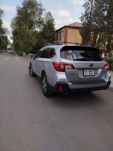 кофр на крышу автомобиля: Универсальный кроссовер Subaru Outback серебристого цвета, оснащенный