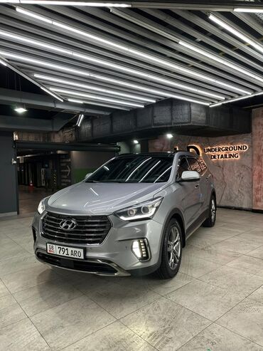 Hyundai: Автомобиль Hyundai Santa Fe серебристого цвета с черной крышей. Это