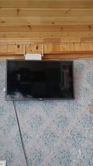 Divara quraşdırılmış qara rəngli LG Smart televizor. Televizorun alt