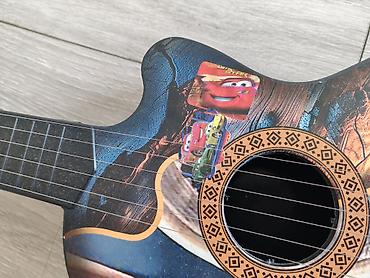 inkişaf etdirici oyuncaqlar: Dekorativ uşaq gitara formasında musiqi aləti. Korpus üzərində — 6