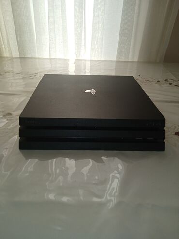 PS4 (Sony Playstation 4): PlayStation 4 Pro oyun konsolu, iki ədəd qara və bir ədəd mavi rəngdə