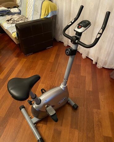 Elliptik trenajorlar: Gümüşü rəngdə, yığcam dizaynlı stasionar velosiped. Məlumatları əks
