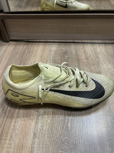 закрытое футбольное поле: Бутсы Nike желтого цвета, предназначенные для футбола, обеспечивают