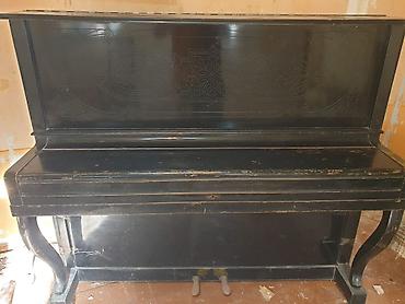 Musiqi alətləri: Upright piano – klassik qara korpuslu, dekorativ oyma panellərlə. - — 2