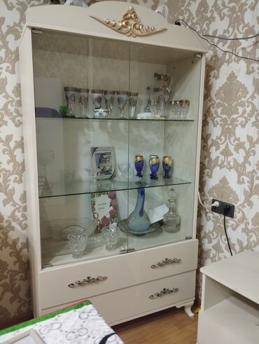 Sifarişlə salon mebeli: Şüşə qapıları və rəfləri olan kremli rəngli vitrin şkafı. Üst