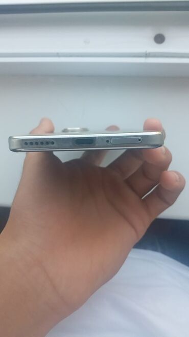 redmi k70 ultra qiyməti: Gümüşü rəngdə, incə dizaynlı smartfon. Cihazın sağ tərəfində səs