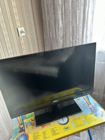 тюнер тв: Телевизор TCL с черной рамкой и подставкой. Подходит для просмотра