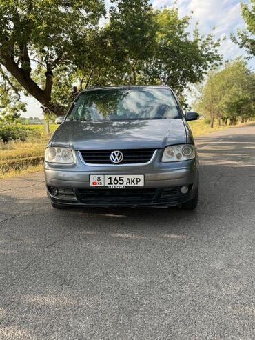 семиместные машины: Минивэн Volkswagen Touran серого цвета. Автомобиль оснащен рейлингами