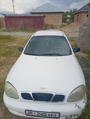 деу лонос: Белый седан Daewoo Lanos с четырьмя дверями, оснащенный черными