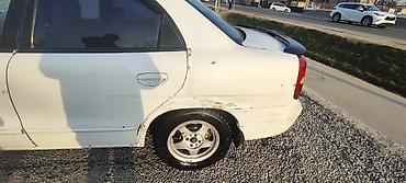 Другие автомобили: Белый седан компакт‑класса с передним приводом. Кузов 4‑дверный, на — 5