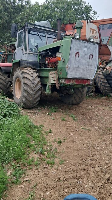 Traktorlar: Yaşıl rəngli, kabinli traktor. Kənd təsərrüfatı və ya digər sahələrdə
