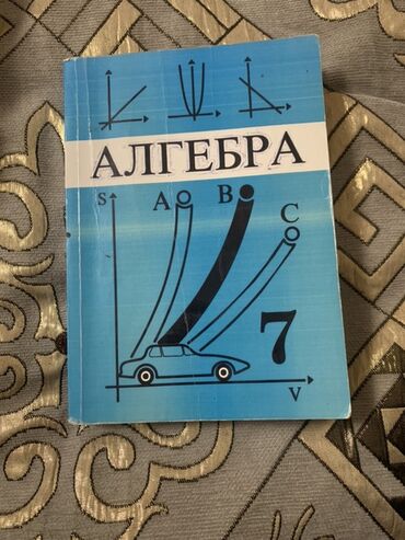 настольный стол: Учебник по алгебре для 7 класса с обложкой голубого цвета. На обложке