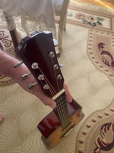 İdman və hobbi: Üstündə çanta, divardan asılqan və simlər verilir Akkustik gitara – — 2