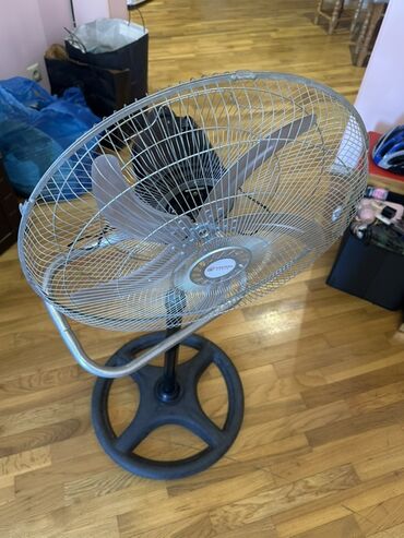 ventilator baku: Yerdə dayanan, metal qəfəsli, qara rəngli dairəvi oturacağı olan