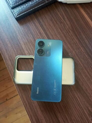 Redmi: Mavi rəngdə Redmi smartfon, arxa tərəfində iki kamera və bir flaş ilə