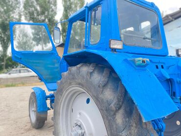 Тракторы МТЗ (Беларус): Трактор МТЗ 80 синего цвета с кабиной. Оборудован передними фарами и — 7