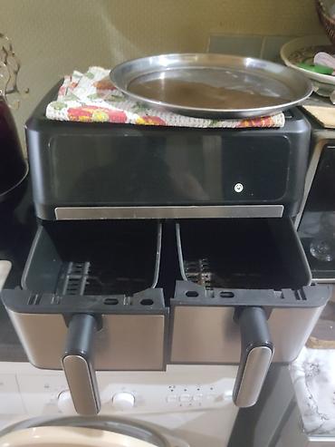 Mətbəx texnikası: İki bölməli hava fritözü (air fryer) təqdim olunur. Cihaz qara və — 2