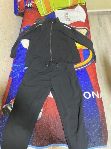 спортивный форма: Спортивный костюм черного цвета, состоящий из куртки на молнии и брюк