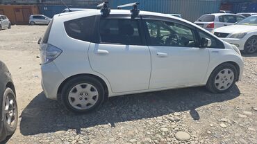 машина в караколе: Белый хэтчбек Honda Fit с гибридной силовой установкой. Автомобиль