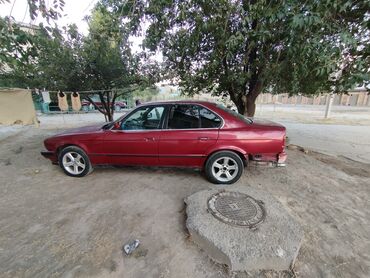блок abs e39: Красный седан BMW E34. Автомобиль имеет характерный классический