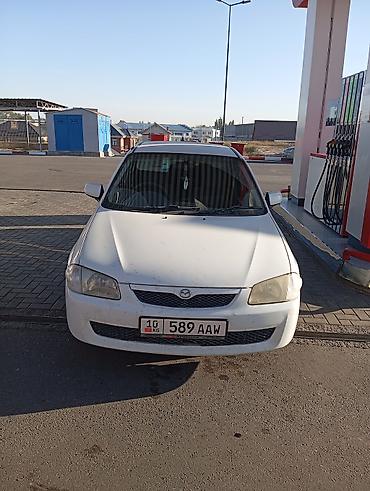 e6 3: Mazda Familia седан, белый цвет. Компактный городской автомобиль с — 4