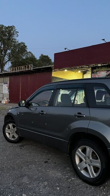 Suzuki: Автомобиль Suzuki Grand Vitara в сером цвете. Эта модель сочетает в