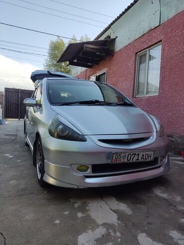 маленькая машина: Серебристый хэтчбек Honda Fit, оснащенный дополнительным багажным